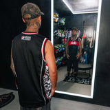 Back of black jersey tank with white-red trim and side graphic stripe paneling.