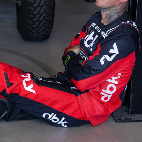 Red and black racing jersey with long sleeves, full zip, and large dbk-style logo graphics