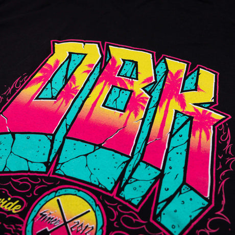 Detailed DBK graffiti-style graphic on black T-shirt with pink and teal blocks