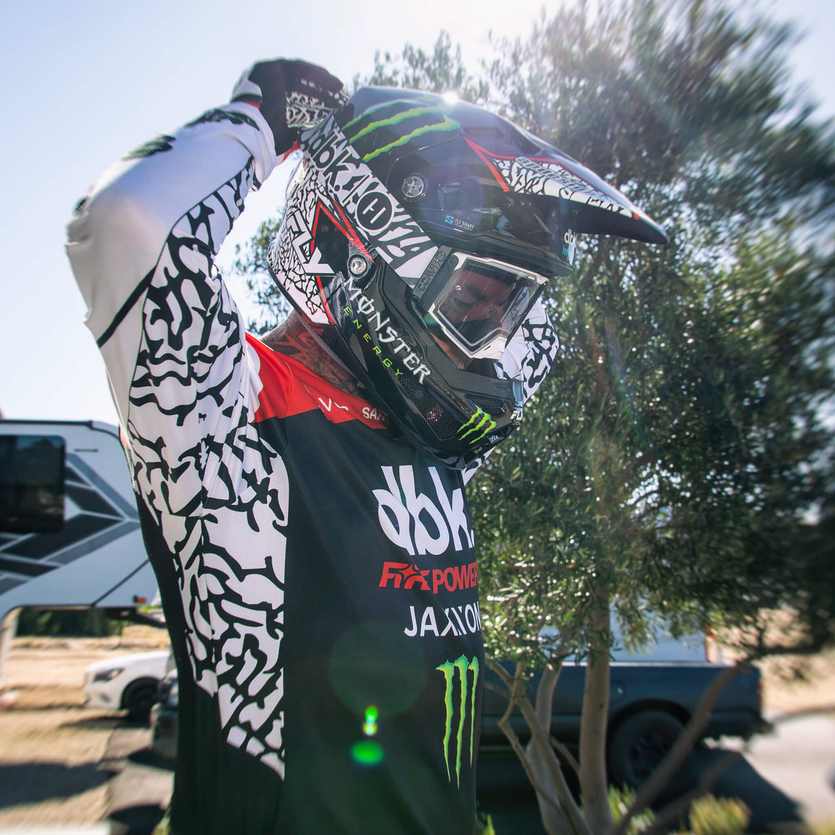 Motorcycle jersey with black body, red panel, and white patterned sleeves