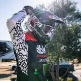 Motorcycle jersey with black body, red panel, and white patterned sleeves