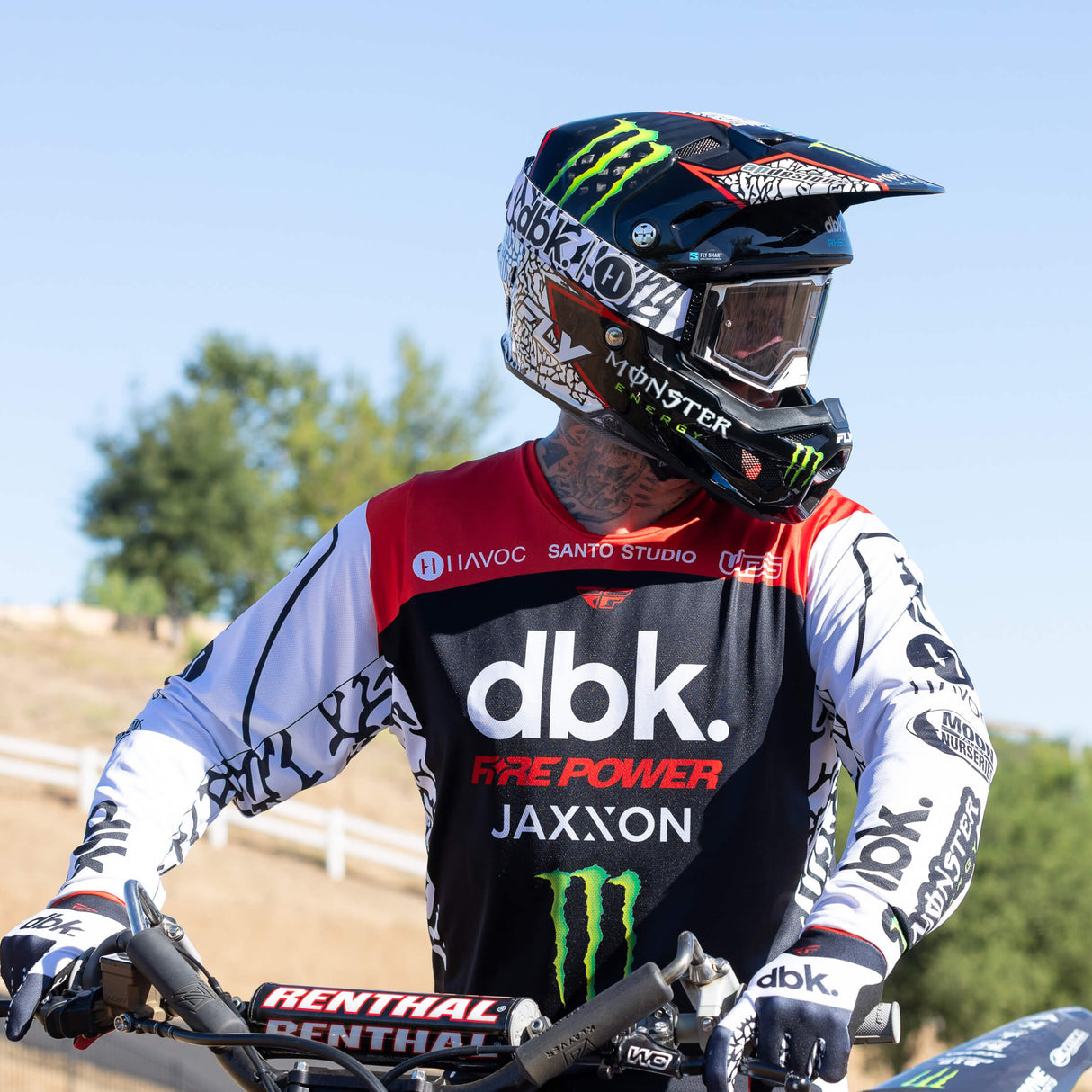 Motorcycle gloves on controls, black-and-white with red accents at the knuckles.