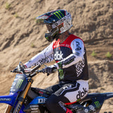 Youth motocross gloves with black base, white pattern, and green accent stripes