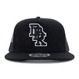 Black trucker cap front view with white DBK 2Fifty logo patch