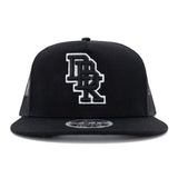 Black trucker cap front view with white DBK 2Fifty logo patch