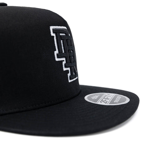 Black trucker cap side close-up with white DBK 2Fifty logo and round brim patch