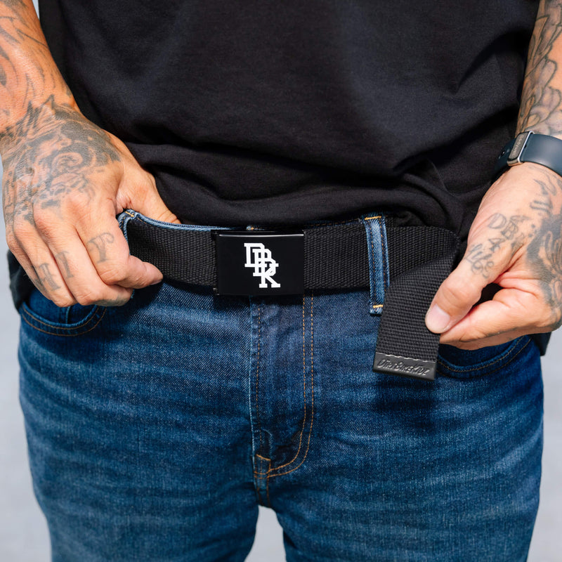 Freerider belt across blue jeans with black woven strap and logo buckle