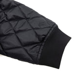 Black quilted jacket sleeve with ribbed cuff and diamond stitch detailing