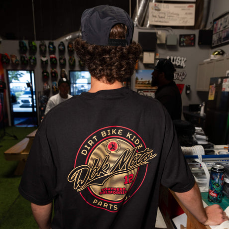 Slugger T-shirt on model in black with large back circular logo graphic