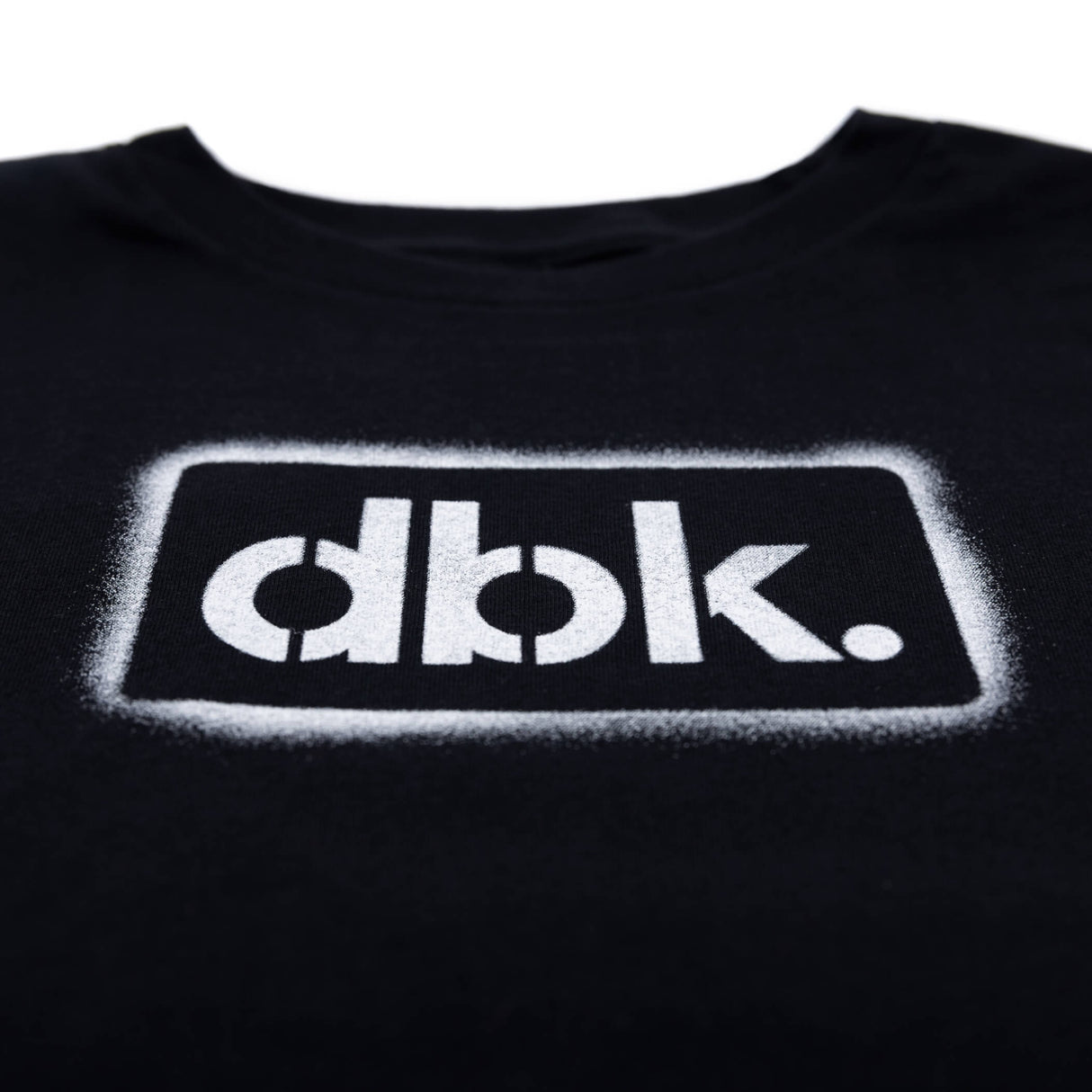 Youth black T-shirt close-up of outlined dbk. logo print