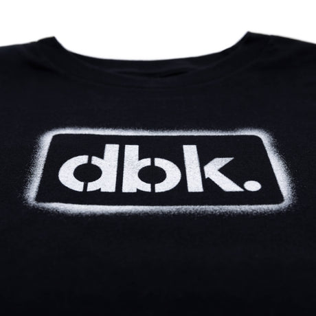 Youth black T-shirt close-up of outlined dbk. logo print