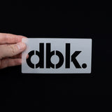 T-shirt stencil card with dbk. logo cutout held in hand