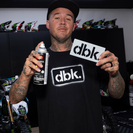 Youth black T-shirt worn by person; front shows dbk. logo print