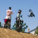 Cream and dark T-shirts worn on riders’ backs with Moto Is Dope prints