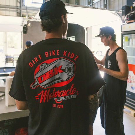 Black Factory Tee worn from behind with large DBK motorcycle parts logo centered.