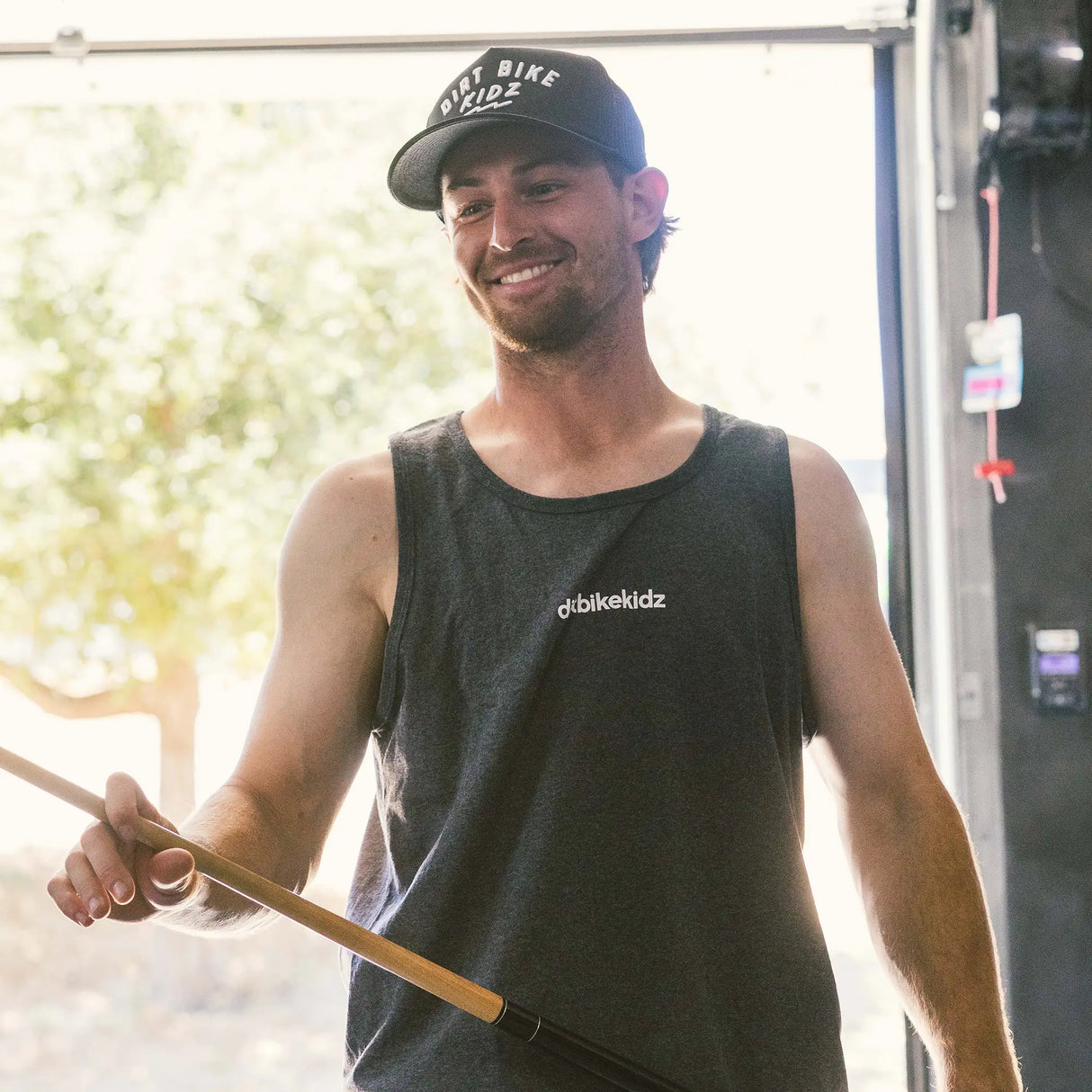 Dark gray sleeveless tank top worn by a person with 'dirtbikekidz' chest logo.