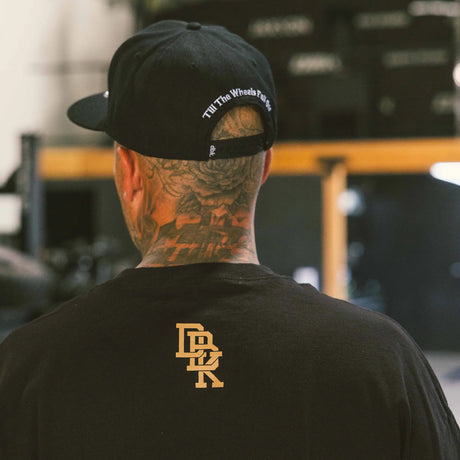 Black Gold Standard tee back, small gold monogram logo