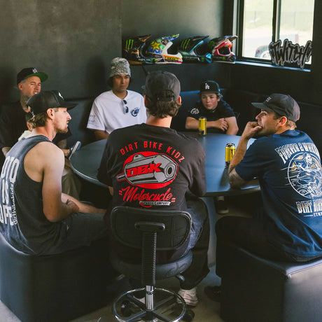 Black Factory Tee worn by group member: large back DBK motorcycle logo graphic.