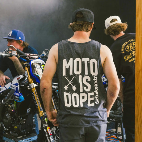 Espalda de camiseta sin mangas gris oscuro con texto grande “MOTO IS DOPE”