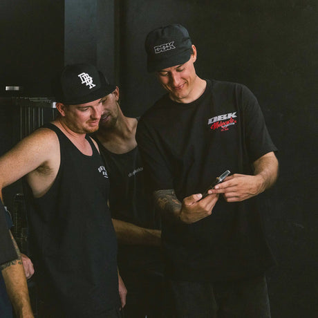 Two men wearing black Factory Tees with small DBK Motorcycle chest logos.