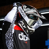 Youth motocross helmet close-up with black shell, white graphics, red accents, and chin area.