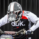 Motorcycle helmet on rider, white with black body and red accents, open visor