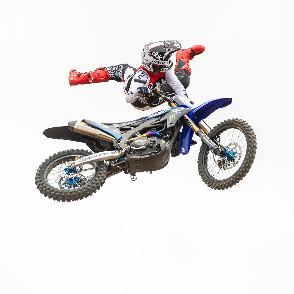 Motorcycle jersey on rider: black center panel, red accents, white sleeves, dbk branding