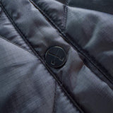 Black jacket snap button on front placket with quilted fabric texture