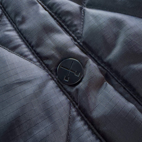 Black jacket snap button on front placket with quilted fabric texture