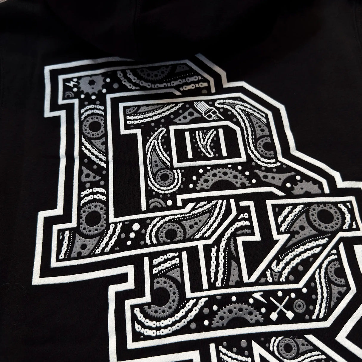 Black hoodie with drawstring hood, front kangaroo pocket, and large white graphic on back