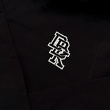 Close-up of black hoodie fabric with small white logo on the left sleeve hem