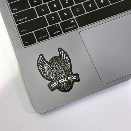 Single winged dirt bike logo sticker with DIRT BIKE KIDZ text on a laptop surface