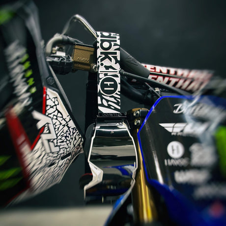 Helios goggle with dark reflective lens and black-and-white logo patterned strap