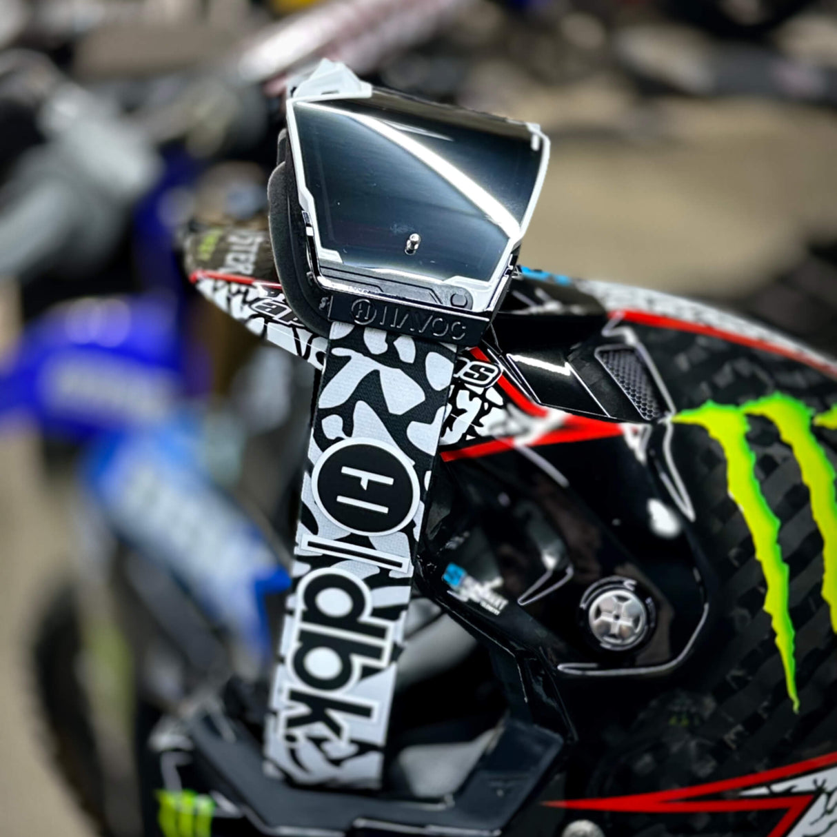 Helios goggle with dark lens, white frame accents, and black-and-white graphic strap