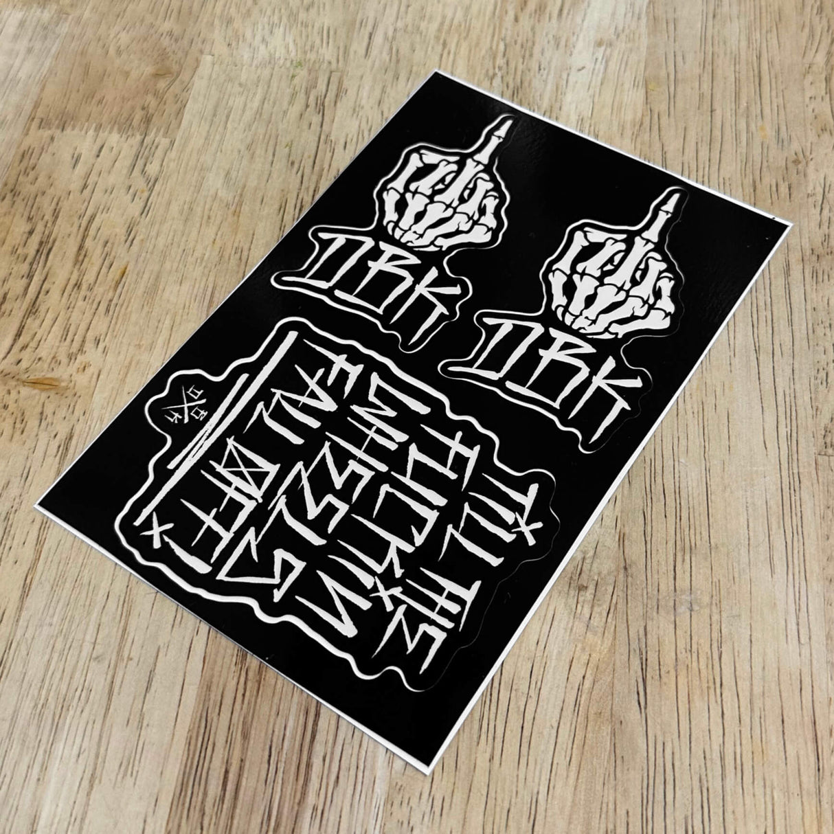 Sticker pack sheet with two raised-finger hands and large graffiti lettering in white on black
