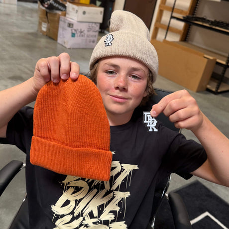 Rust orange ribbed beanie with front stitched logo patch