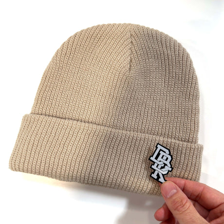 Tan ribbed knit beanie with front stitched logo patch