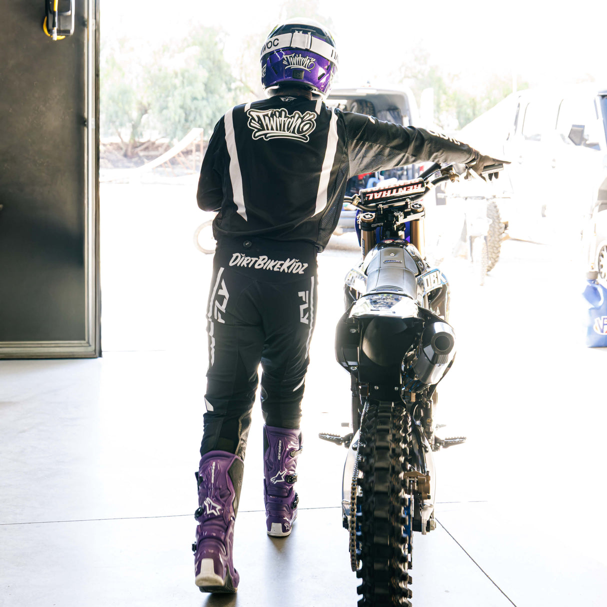 Black riding pants with white vertical logo stripe and knee armor padding