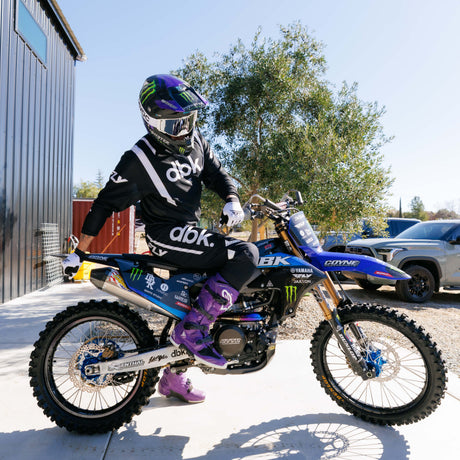 Black motocross pants with bold white dbk lettering and armored knee area