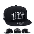 Black snapback cap with large white DBK graphic on the front panel