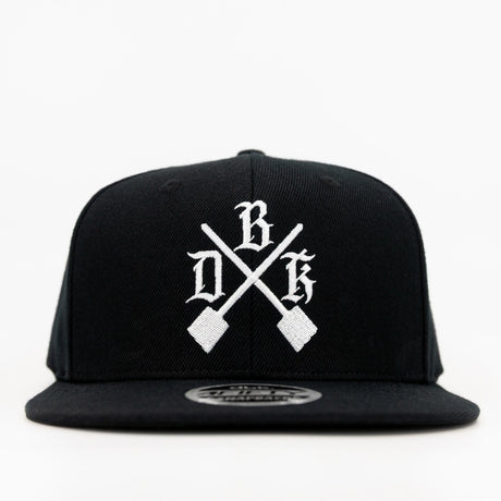 Black snapback with white cross-design graphic and flat brim
