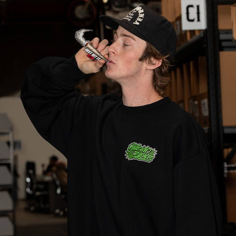 Schwarzer Crewneck mit grünem Brustlogo, Modellansicht mit langem Ärmel