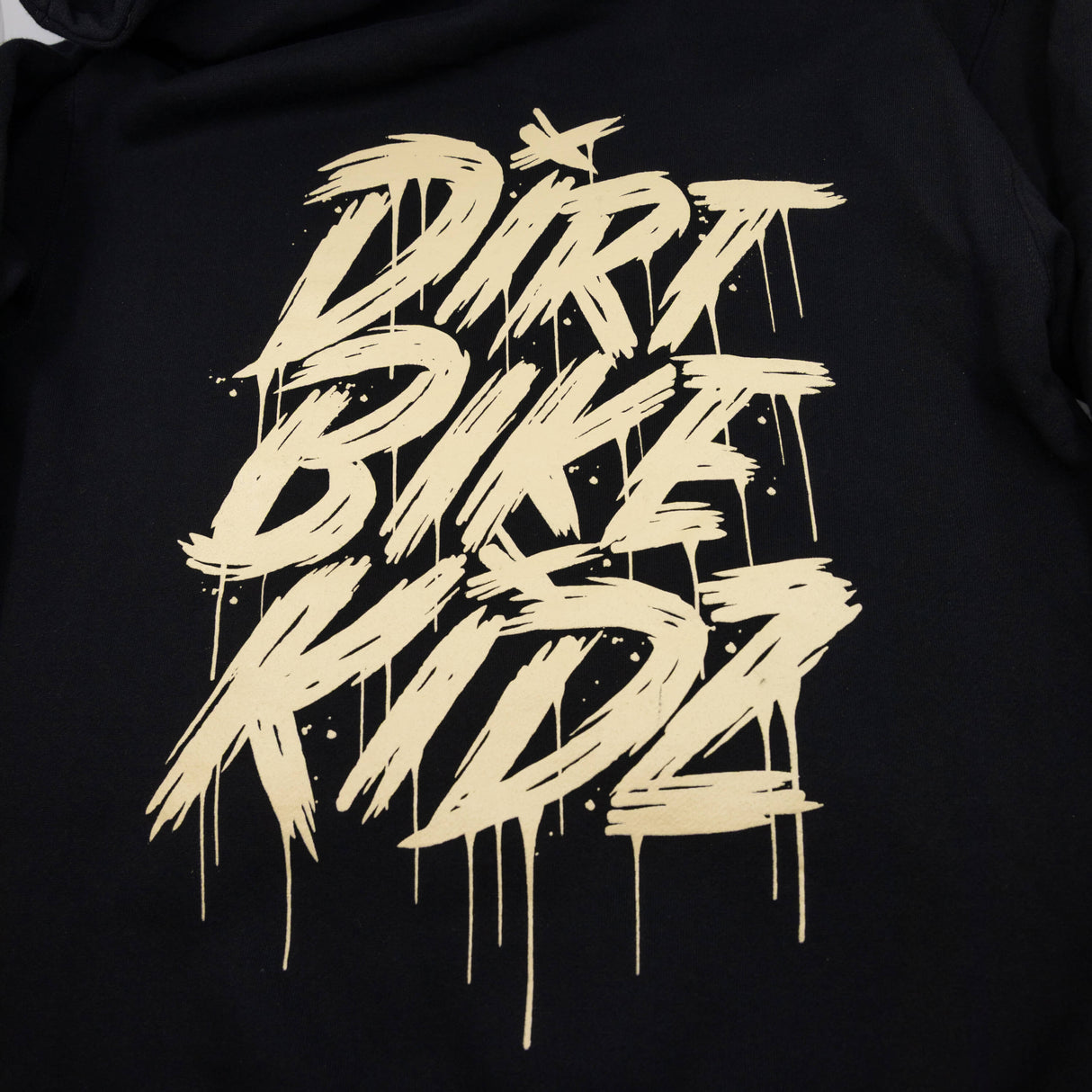 Black hoodie fabric with large gold distressed graphic print on the back