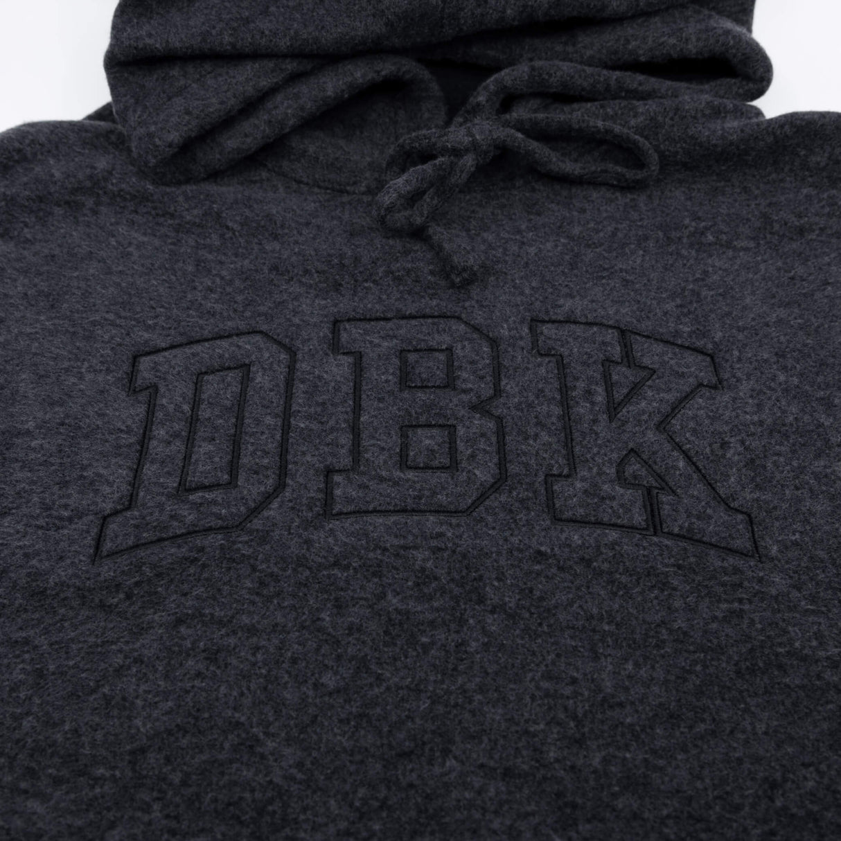 Women’s dark charcoal pullover hoodie close-up of front logo and drawstring hood