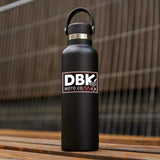 DBK Moto Co sticker on black bottle, small white and red logo with cartoon character
