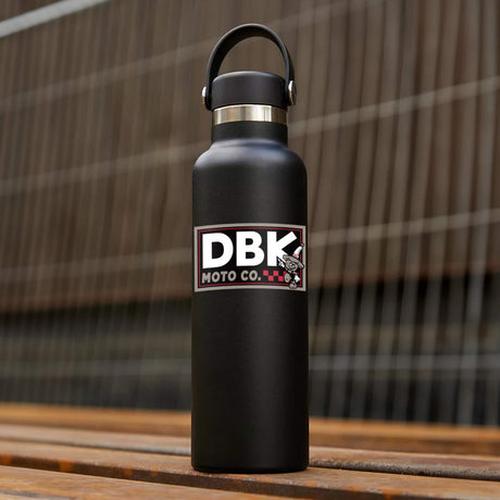 DBK Moto Co sticker on black bottle, small white and red logo with cartoon character