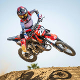 Youth motocross pants on rider, black and light gray with red color-blocked panels