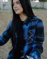 Women’s blue-and-black plaid flannel shirt with button-front and chest patch logo