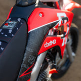 Motorcycle side panel with red paint and white graphic decal near the seat