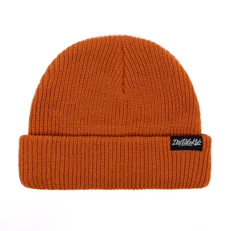 Rust orange knit beanie with folded cuff and small black logo patch